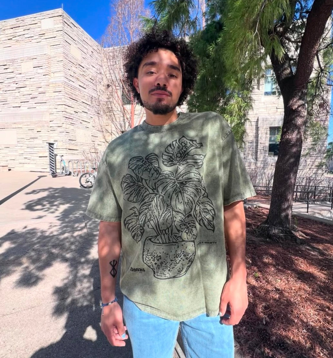 A model wearing the JOHNSONANDSCOTT and Green Society collaboration shirt outdoors.
