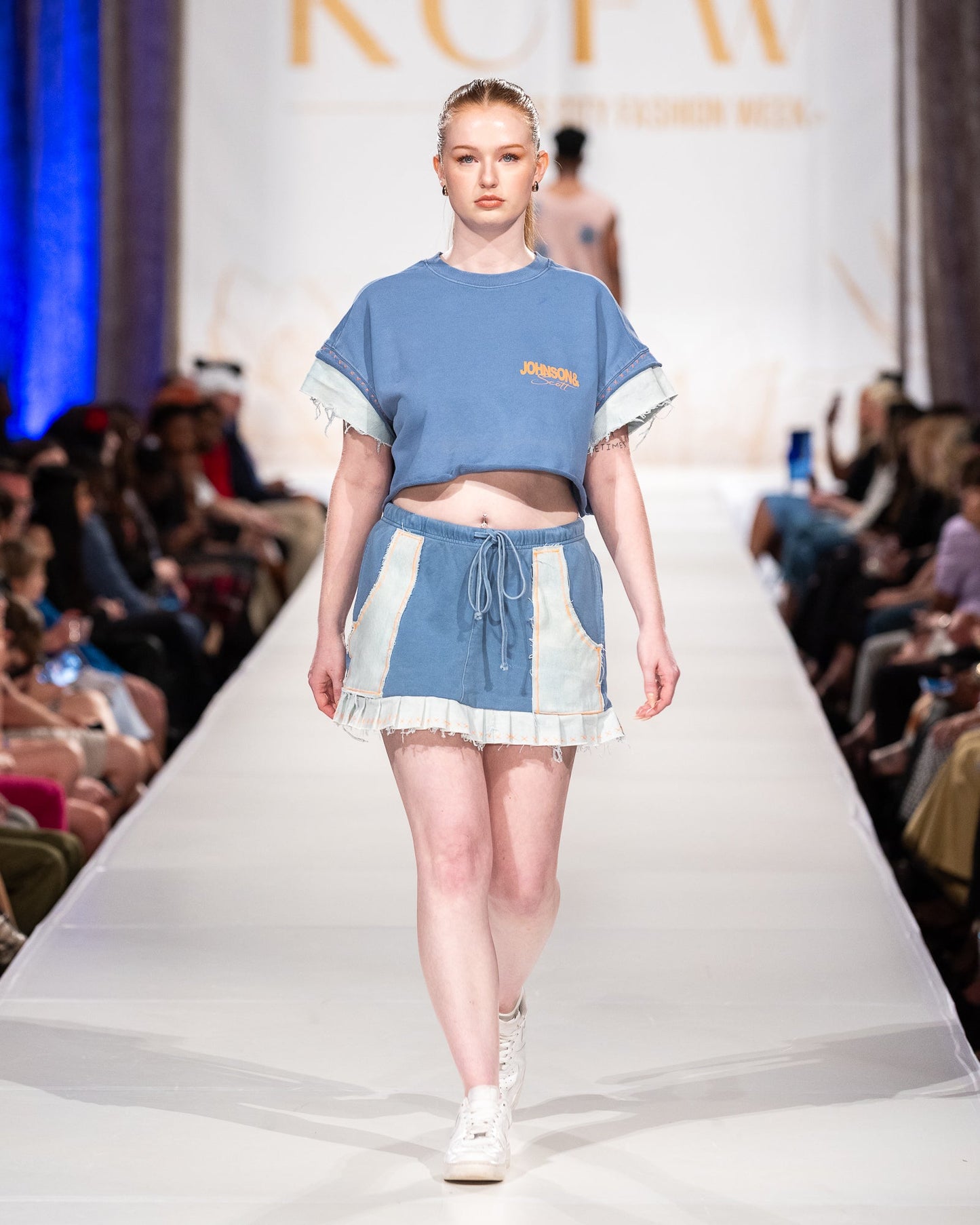 A model wearing a reconstructed blue JOHNSONANDSCOTT look on the runway.